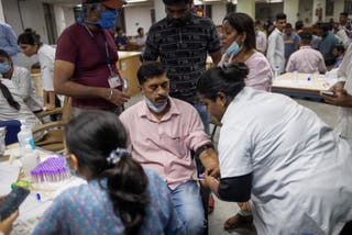 A health official takes a DNA sample from a family member of one of the victims who died